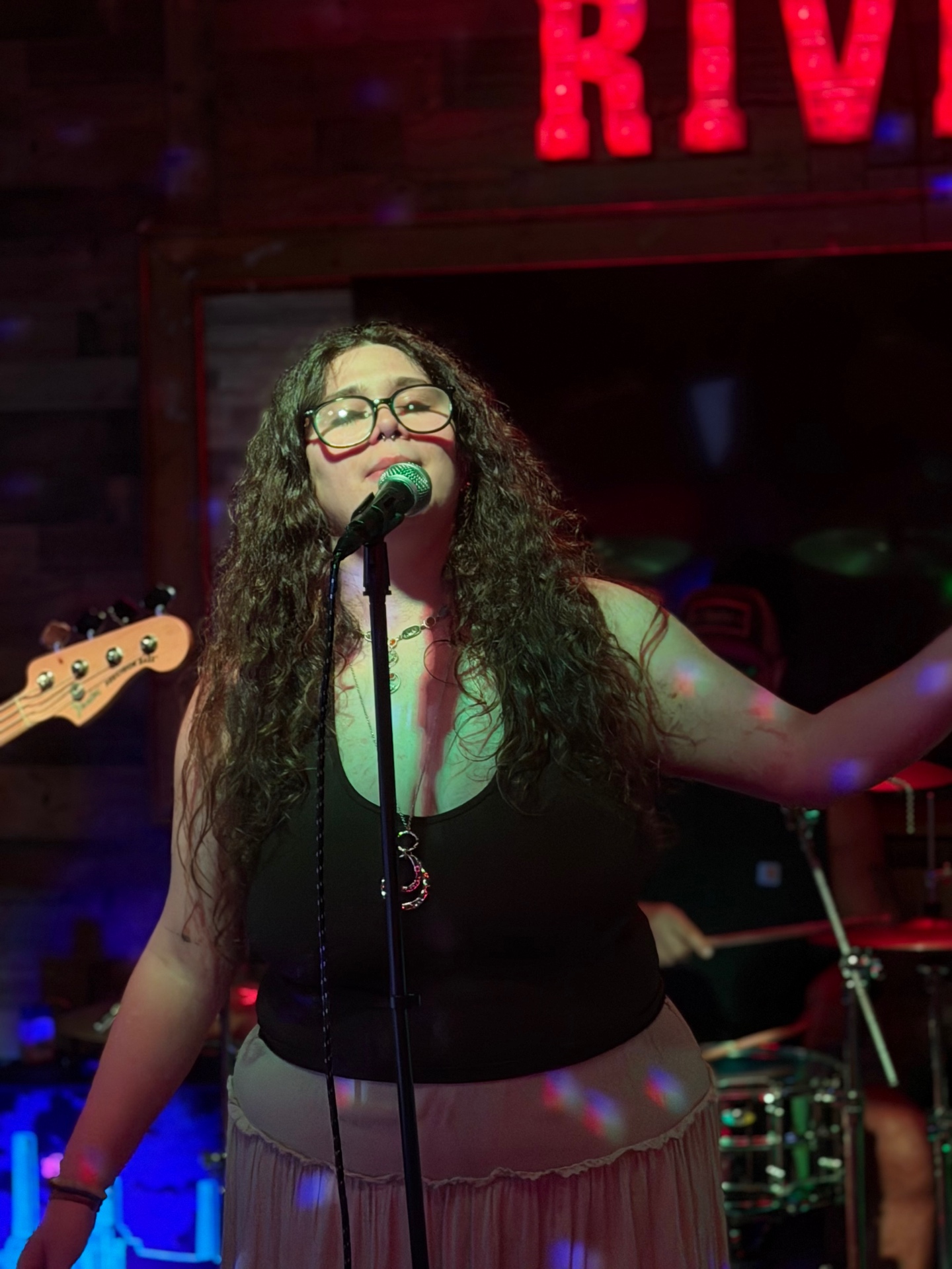 Emma singing under the Whiskey River neon sign